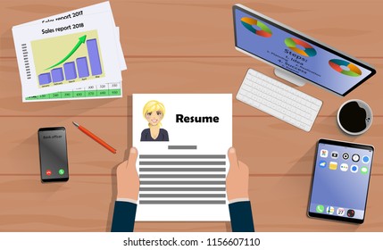 Top view on hands with Resume above desk with laptop,mobile, tablet and other business accessories. Modern business workplace