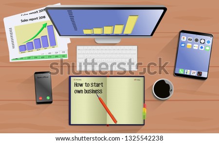 Top view on laptop computer with mobile phone and tablet on office desk. With Business notebook (diary) with text How to start own business. Modern business workplace