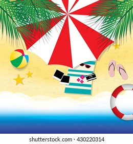 Top view of the sea beach and the sea with the waves. On the beach under beach towels spread out towels and beach accessories