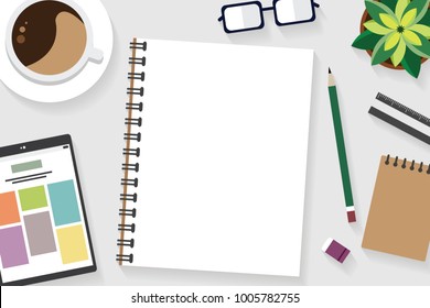 Top view of table working and working desk with gadget and free space for text with accessory on the table, tablet, note, book, pen, flowerpot, glasses, coffee cup