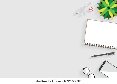 Top view of table working and working desk with gadget and free space for text with accessory on the table, notebook, phone, pen, flowerpot, glasses