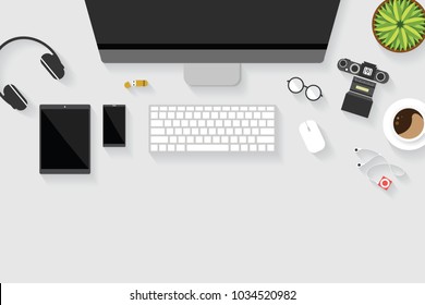 Top view of table working and working desk with gadget and free space for text with accessory on the table, desktop, keyboard, camera, flowerpot, glasses, earphone, mouse, coffee cup