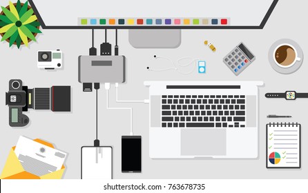 Top view of table working with gadget and working desk with accessory on the table, laptop, notebook, desktop, phone, flash drive, coffee cup, letter, flowerpot, note, camera, pen, calculator