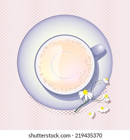 Top view of a tea cup,saucer and chamomile sprig 