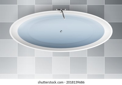 Top view of a white modern bath tub filled with clear water standing on tiled bathroom floor
