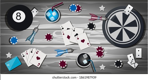 Top view of a wooden table with items for gambling and sports games. Table with items for playing Darts, bowling, cards, poker, dominoes, casino chips. The card for party with presents. Greeting card