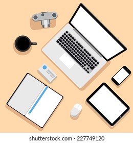 Top view of workplace with laptop, tablet, camera, smartphone, stationery and documents