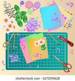 Top view of workspace with elements for scrapbooking and papercrafting, tools for decoration and handmade