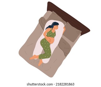 
Vista superior de una joven embarazada en pijamas durmiendo sobre una almohada de maternidad en la cama. Dormitorio nocturno saludable. Posición cómoda para dormir, Preparación para el parto. Atención de la salud y del embarazo. 