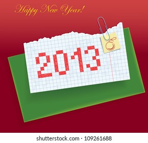Torn exercise book in the box with a painted date "2013". Paper sheets and a green envelope fastened clip. Congratulations on the new year