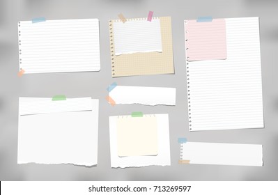 Torn ruled, blank, squared note, notebook, copybook paper strips, sheets stuck with colorful sticky tape on gray background.