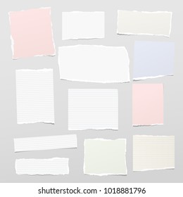 Torn white and colorful pastel note, notebook paper strips stuck on gray background.