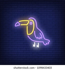 Toucan neon sign. Tropical bird on dark brick wall background. Night bright advertisement. Vector illustration in neon style for pet shop or zoo