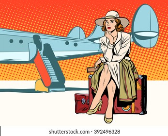 Tourist girl sitting on a suitcase, travelling by plane