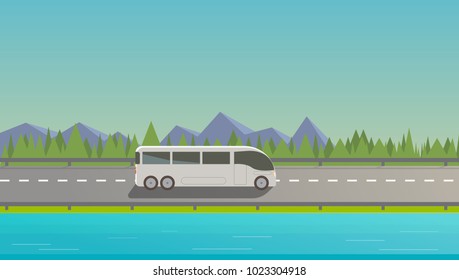 Touristic white bus driving on freeway. Nature background, mountains, trees, lake.