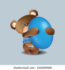 A toy brown bear in a blue T-shirt is holding a large Easter egg.