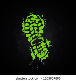 A trace from a boot on a black background. A green imprint of a sports boot. Stylized footprint