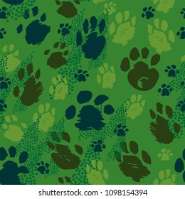 Traces of animals of different sizes in gray, beige and brown colors seamless pattern on green background.