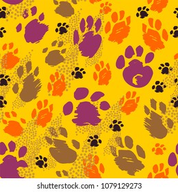 Traces of animals of different sizes in purple, orange, brown and black colors seamless pattern on yellow background