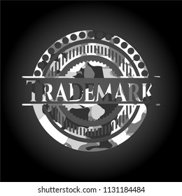 Trademark written on a grey camouflage texture