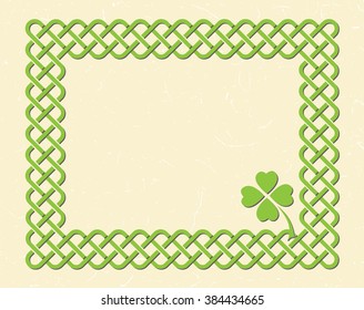 Traditional green celtic style braided knot frame and shamrock leaf over textured vintage background.