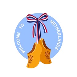 Traditional Wooden Holland Shoe "Klomp", Dutch Clogs, Souvenir Of Netherlands, On White Background. Pair Of Traditional Yellow Wooden Shoes With With A Ribbon In The Colors Of The Dutch Flag.