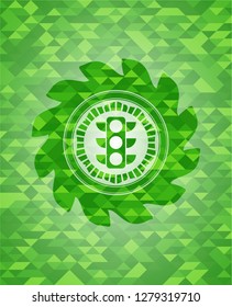 traffic light icon inside green emblem with triangle mosaic background