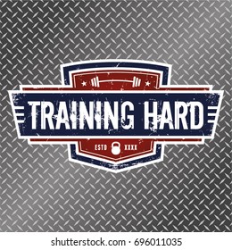 Training Hard - Vector Illustration. A grunge style logo featuring a kettlebell and a barbell.