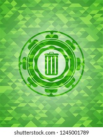 trash can icon inside green emblem with triangle mosaic background