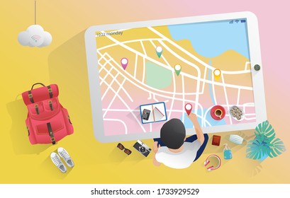 Travel planning concept. Top view on travel, a man preparing, packing checklist, a suitcase, credit card, map,  air ticket, camera, sunglasses, a cup of coffee, passport, tablet with a booking website