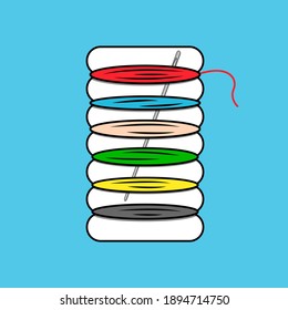 Travel set of colored threads on cardboard. The needle is stuck inside.