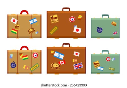 Travelers suitcases with the stickers. The objects are isolated against the white background and shown from one side