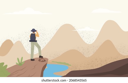 traveller or explorer standing on top of mountain or cliff and looking on valley