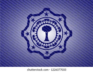 tree icon inside badge with denim texture