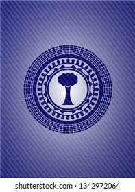 tree icon inside badge with denim texture