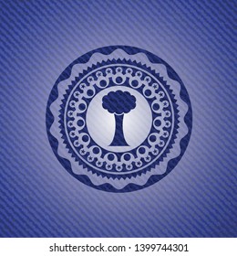 tree icon inside emblem with denim texture