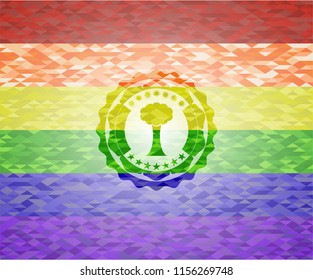 tree icon inside emblem on mosaic background with the colors of the LGBT flag