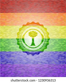 tree icon inside emblem on mosaic background with the colors of the LGBT flag