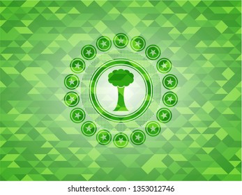 tree icon inside green emblem with triangle mosaic background