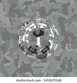tree icon inside grey camouflage emblem