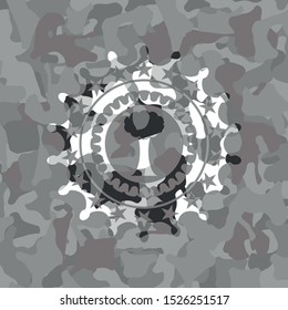 tree icon inside grey camouflaged emblem