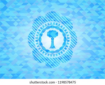 tree icon inside light blue mosaic emblem