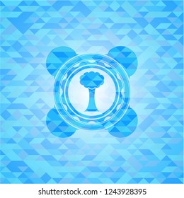 tree icon inside light blue emblem with triangle mosaic background