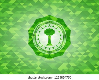 tree icon inside realistic green emblem. Mosaic background