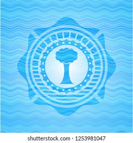 tree icon inside sky blue water wave style badge.