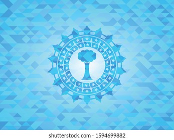 tree icon inside sky blue emblem with triangle mosaic background