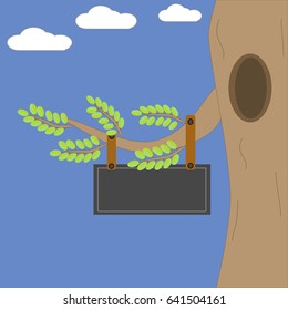 A tree with leaves on blue background with a black board hanging from the branch with copy space