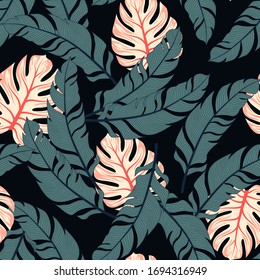 Trend seamless tropical pattern with bright plants and leaves on a black background. Seamless exotic pattern with tropical plants. Hawaiian style.