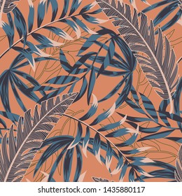 Trending bright seamless pattern with colorful tropical leaves and plants on orange background. Vector design. Jungle print. Floral background. Printing and textiles. Exotic tropics. Summer design.