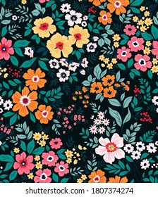 Trendy seamless vector floral pattern. Seamless print made of small multicolored flowers and green leaves . Summer and spring motifs. Black background. Vector illustration.